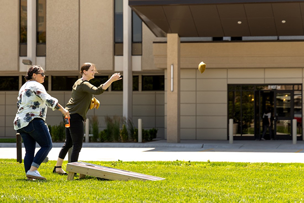 two people playing corn hole board game